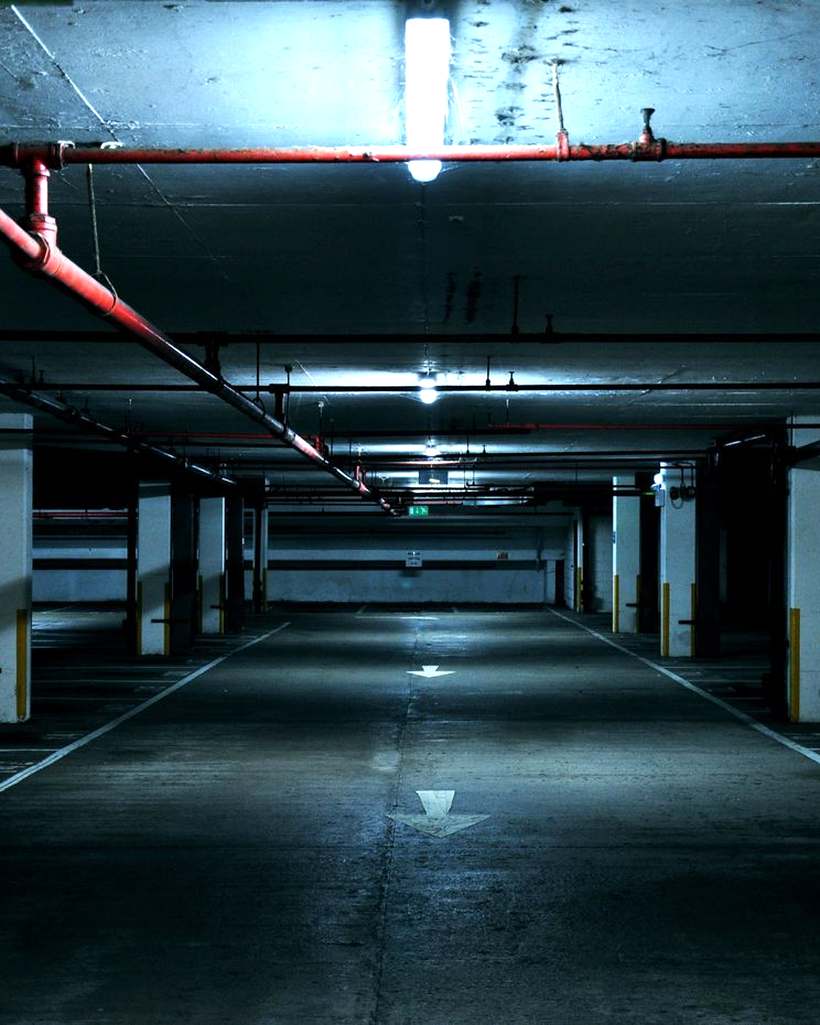 Empty underground car park lit by strip lights